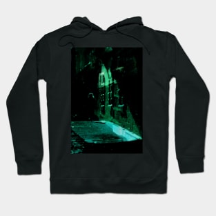 Special processing. Person walking at night, on dark street, with stone walls. Green. Hoodie